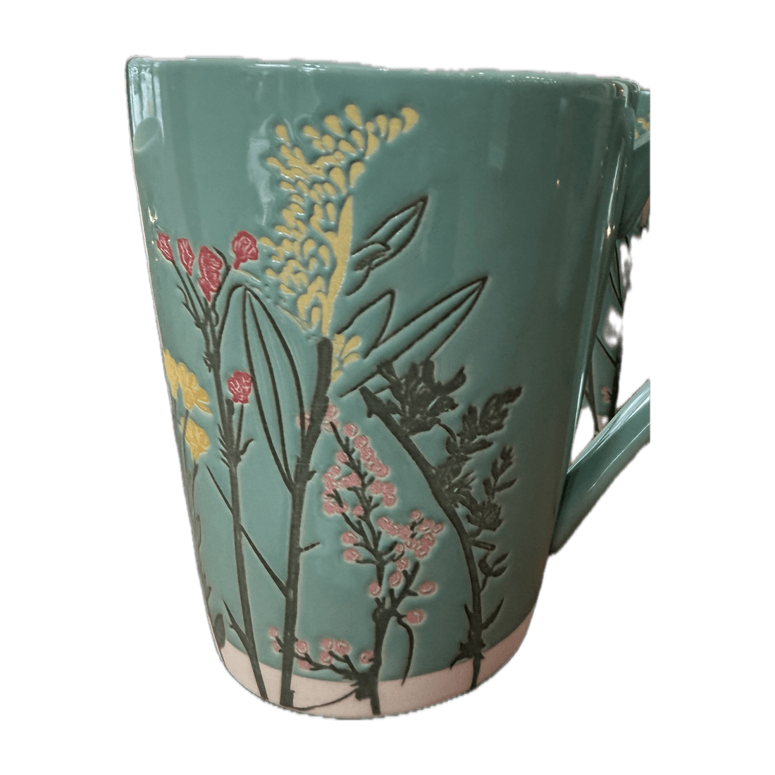 Hellgrüner Becher mit einem Relief aus gelben und rosafarbenen Blumen.
